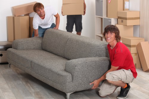 Household removals team carrying furniture through a Plumstead property